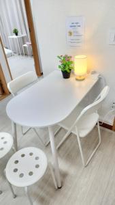 a white table and chairs with a lamp and a plant at Jaja Gwangan in Busan