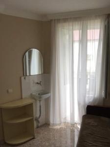 a bathroom with a sink and a window with a mirror at tata's house in Kobuleti
