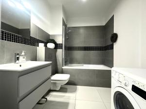 Un baño con lavabo, inodoro y ducha. en Dubois 7 Apartment - Self Check-In 20h - LIFT, en Wroclaw 12 fotos más