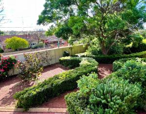 a garden with bushes and flowers and a tree at Bõucher Manor - Northam in Northam +41 photos