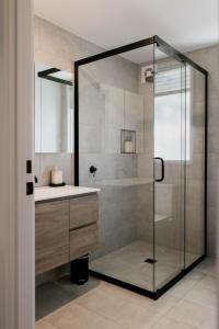 Un baño con ducha de cristal y lavabo. en Newdegate St North Hobart, en Hobart