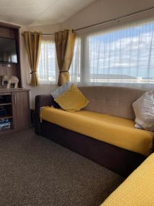 a living room with a couch and a window at Crimdon dene bay view holiday home NO SMOKING NO PETS in Durham