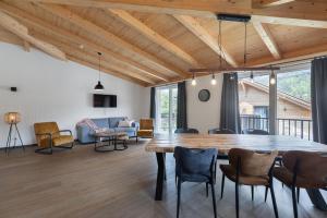 uma sala de estar com uma grande mesa de madeira e cadeiras em Michal em Rattendorf