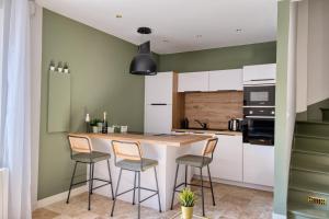 a kitchen with white cabinets and a table and chairs at Maison cosy rénovée, tout à pied, plage et gare in Trouville-sur-Mer +12 photos