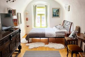 a bedroom with a bed and a tv and a window at Apartmán Veles Banská Štiavnica in Banská Štiavnica