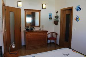 a bathroom with a sink, mirror and a chair at Serra e Mar in Sintra