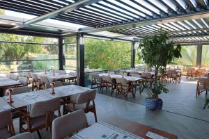 a restaurant with tables and chairs and windows at Taga Hotel in Bitez