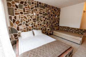 a room with a bed and a stone wall at Stefanidis studios in Stavros