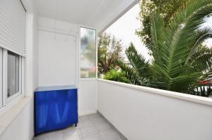 une armoire bleue dans une chambre blanche avec une fenêtre dans l'établissement Apartment Ivan, à Split