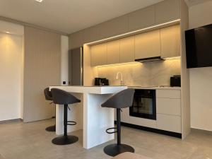a kitchen with two bar stools and a counter at VITHΟS SUITE Luxury Living in Virós