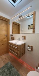 ein Badezimmer mit Waschbecken und Spiegel in der Unterkunft Haus an der Sieber in Herzberg am Harz