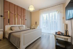 a bedroom with a bed and a large window at Villa Lima in Ustka