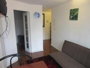 a living room with a couch and a clock on the wall at Departamento Paseo Bulnes Parking a pagar in Santiago