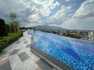 a swimming pool with blue tiles on top of a building at Astra sky river five star condo in Chiang Mai