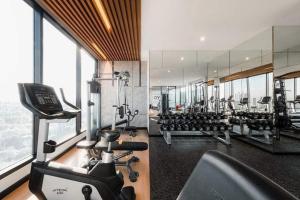 a gym with several treadmills and a large mirror at Astra sky river five star condo in Chiang Mai