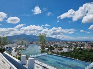 a swimming pool with a view of a city at Astra sky river five star condo in Chiang Mai