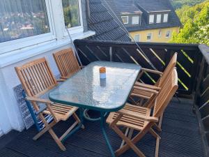 a table and chairs on a balcony with a drink on it at Maisonette - apartment in Siegen in Siegen +23 photos