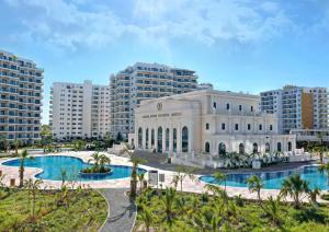 a building with a pool in front of some buildings at CEASAR RESORT STUDIO Consus in Aglantzia
