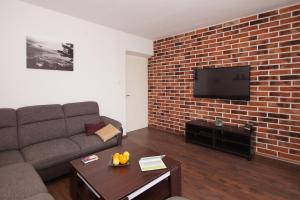科爾丘拉的住宿－Apartment Banje，带沙发和砖墙的客厅