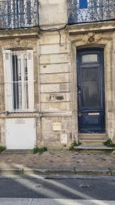 a blue door on the side of a building at Studio Gauche Calme Proche Gare Climatisation in Bordeaux +11 photos