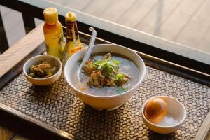 a bowl of soup on a table with bowls of food at ที่พัก in Ban Ko Doi Tung +8 photos