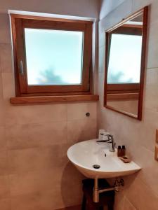 a bathroom with a sink and two windows at Staulir Affittacamere in Meduno