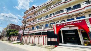 a hotel with a red sign in front of a building at Hotel Shivam Grand Inn in Gorakhpur