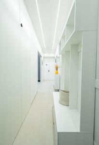 Un pasillo blanco con gabinetes blancos y pisos blancos. en Casa Gemma Rome, en Roma 27 fotos más