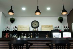 a bar with two chairs and a clock on the wall at Galeria hotel in Jaú