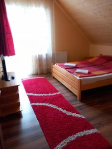 1 dormitorio con cama y alfombra roja en Krisztina Kulcsosház Ivo, en Izvoare