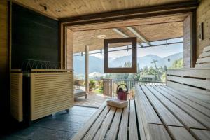 a room with a wooden bench and a large window at Das.Goldberg in Bad Hofgastein