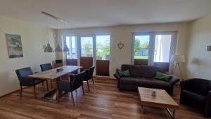 a living room with a couch and a table and chairs at Ferienwohnung Seeblick in Altefähr