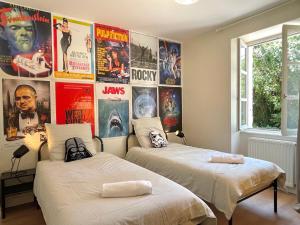 two beds in a room with posters on the wall at Le Ciné-Club - Appartement signature in Amplepuis