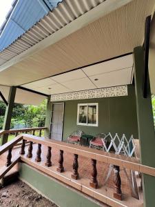 ein Balkon eines Hauses mit einem Tisch und Stühlen in der Unterkunft Well Living Guesthouse Khaolak in Khao Lak