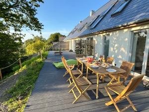 a wooden table and chairs on a deck at Westertilli Middelhuus - modernes, luxuriöses Wohngefühl in Pellworm