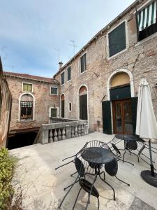 a patio with chairs and a table and an umbrella at Bed and Breakfast Querini San Marco in Venice