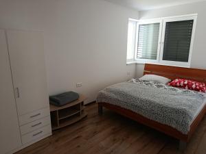 a bedroom with a bed and a table and two windows at Apartmán Bobrov in Bobrów