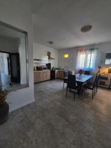 a dining room and kitchen with a table and chairs at Apartments Margareta & Ena in Malinska +16 photos