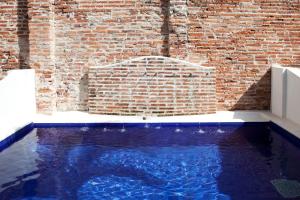 a stone wall with a pool of water in front of it at Alfiz Hotel in Cartagena de Indias