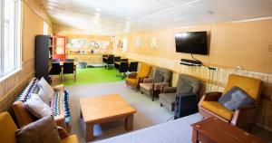a waiting room with chairs and a table and a tv at Danseys Pass Holiday Park in Oamaru +41 photos