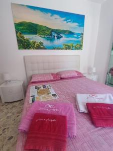 a bedroom with a bed with pink sheets and towels at Anna e Augusto B&B --Embrace the world--4-minute walk from the Old Town丨Authentic local experience丨English-speaking staff and Wi-Fi - free shuttle to the station in Lucera
