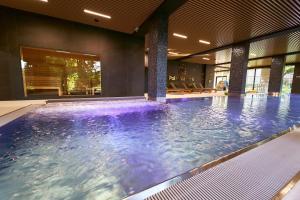 a swimming pool with purple water in a building at Polanica Park -LAGUNA - PREMIUM 2 in Polanica-Zdrój