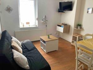 a living room with a couch and a table at Beau T3 - à proximité de la plage ! in Merlimont