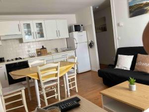 a small kitchen and living room with a table and chairs at Beau T3 - à proximité de la plage ! in Merlimont