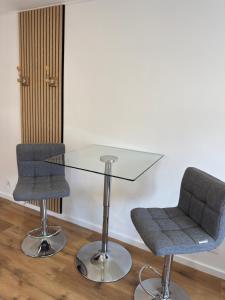 a glass table and two chairs in a room at Petit nid pour 4 personnes-hyper centre in Niort +2 photos
