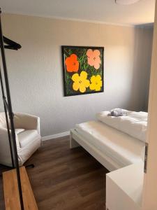 a room with a bed and a picture of flowers at Ruhige Oase & Vollausstattung - AS1A in Weißenfels +5 photos