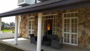 a patio with chairs and a table on a building at Hide Out Hills Bungalow in Nuwara Eliya +17 photos