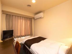 a hotel room with a bed and a television at New Gloria Oita Hotel in Oita +41 photos
