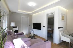 a living room with a purple couch and a tv at Apartment Cobco in Kostrena