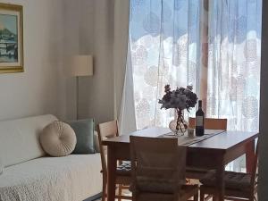 a dining room table with a vase of flowers on it at G&B Apartments in Tignale +23 photos